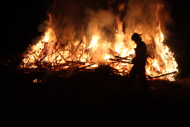 Woodbury Firefighter Nick Abouzeid silhouetted against the controlled burn of 253 discarded Christmas trees Jan 21st